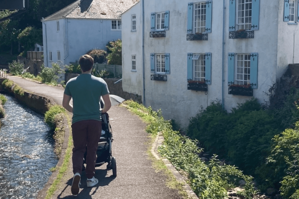 Matt is pushing baby Sam in his pram by a canal path.