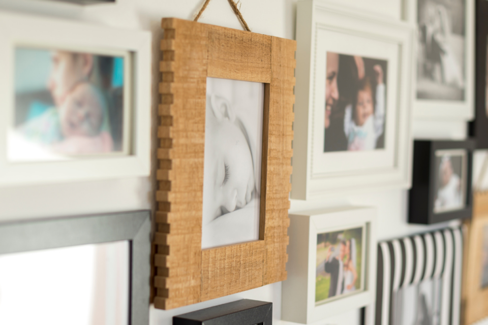 A photo of a collection of images on a wall. It is family photos, predominantly babies.