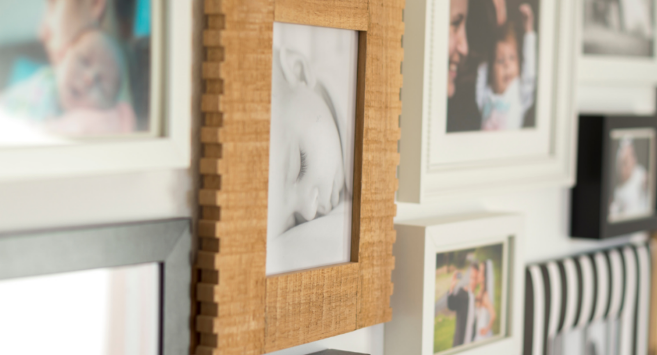 A photo of a collection of images on a wall. It is family photos, predominantly babies.