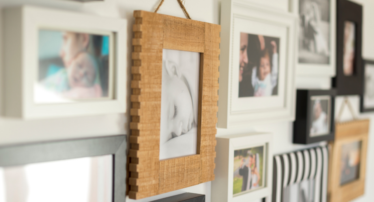 A photo of a collection of images on a wall. It is family photos, predominantly babies.