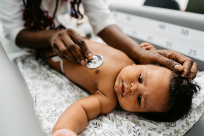 Baby is being checked over by a heath professional.