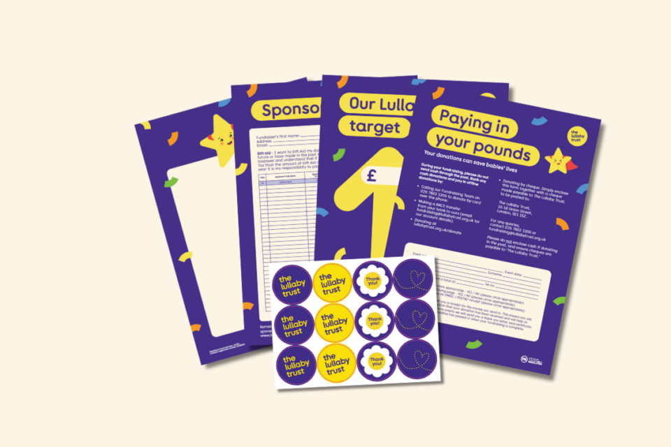 A selection of The Lullaby Trust's fundraising posters, stickers and other paper resources on a cream background