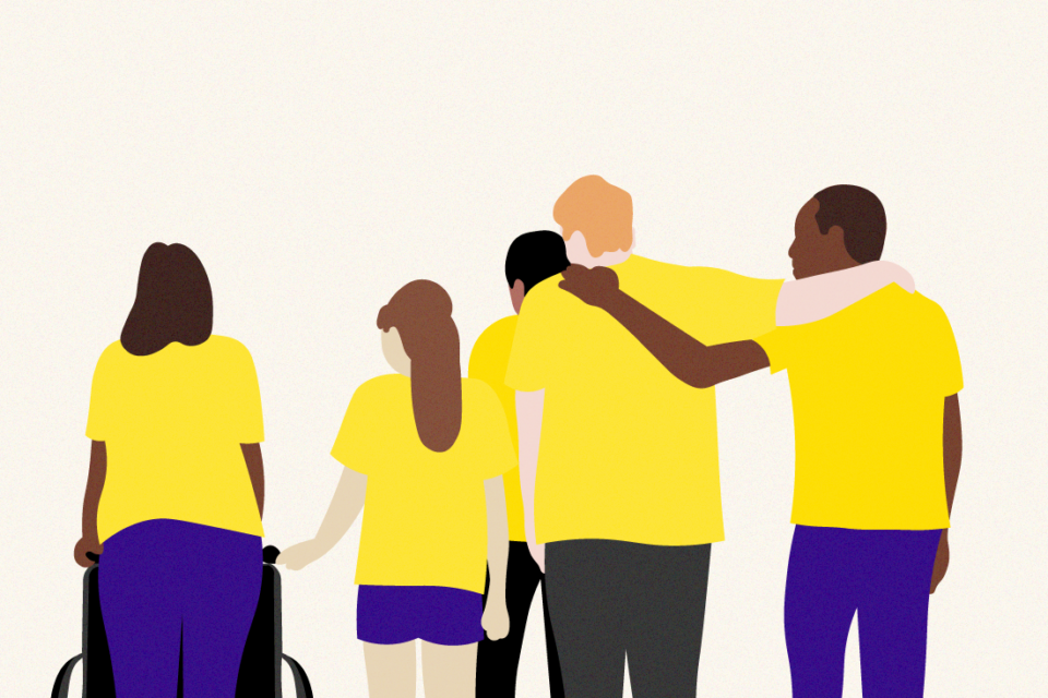 Five people wearing yellow t-shirts standing with their back to us. Two people have their arms around each other.