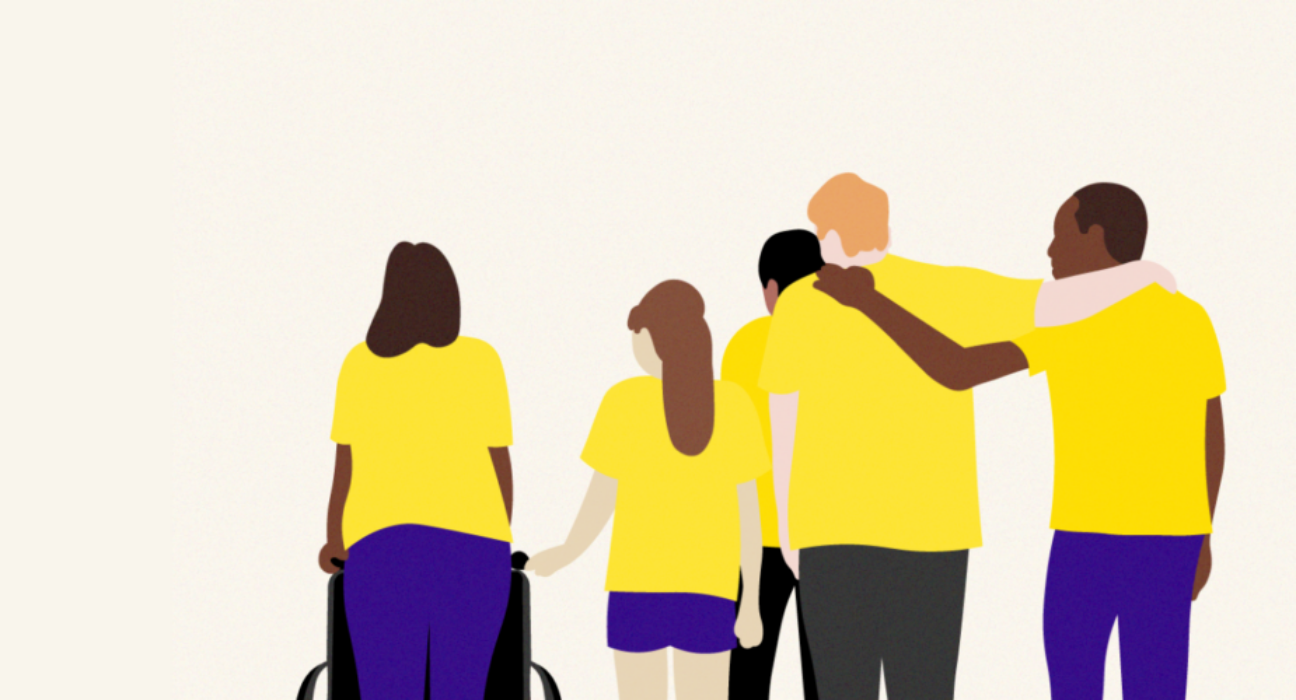 A group of people are supporting one another. They are different ages and from different backgrounds. One is pushing a wheel chair, and another has an arm around another person. It has a supportive feel.