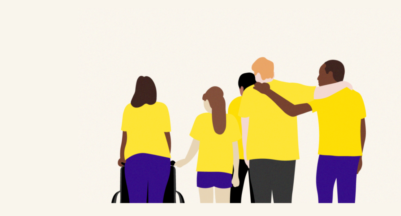 A group of people are supporting one another. They are different ages and from different backgrounds. One is pushing a wheel chair, and another has an arm around another person. It has a supportive feel.