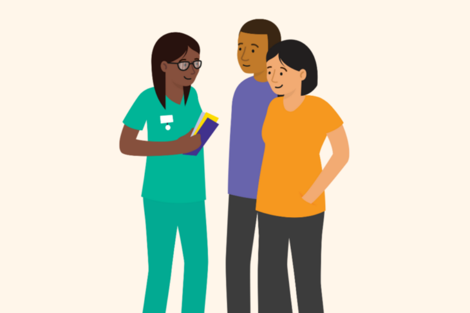 A health professional speaks with a couple. The woman is pregnant. The couple are looking and engaging with the health professional, who is holding booklets in her hand.