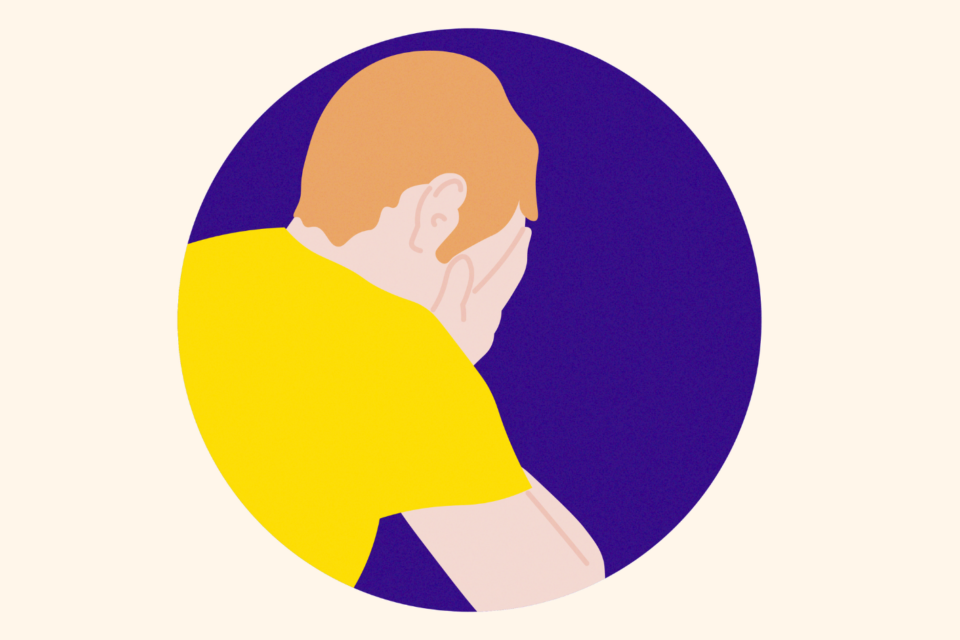 Man in a yellow t-shirt with his head in his hands, on a purple background.