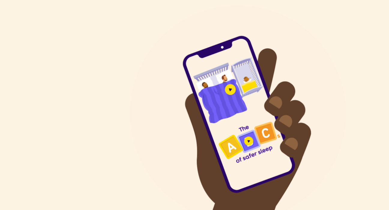 Hand holding a phone looking at safer sleep videos.
