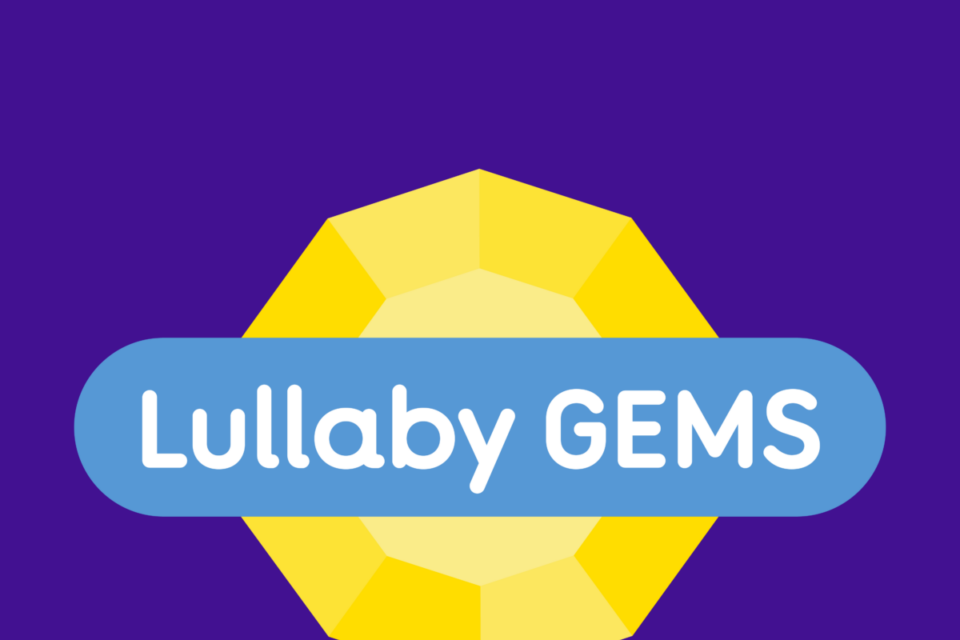 A yellow gemstone on a purple background. Through the middle of the gem is a blue banner with text that says 'Lullaby Gems'