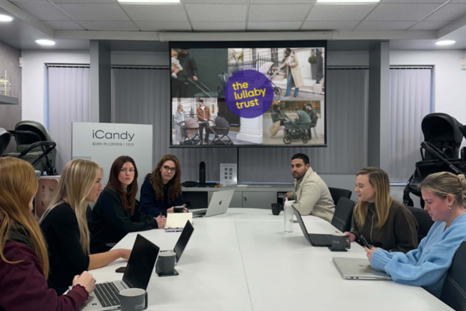 Colleagues sat around a desk listening to a presentation