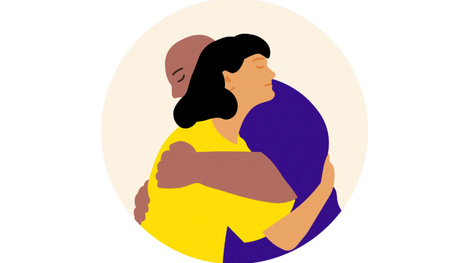 Two people hugging each other supportively.