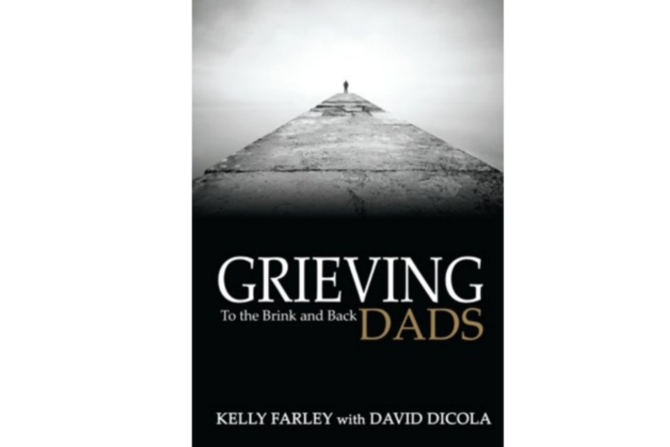 Front cover of the book 'grieving dads'. Dark grey and black front cover of a man standing far in the distance at the end of a long path.
