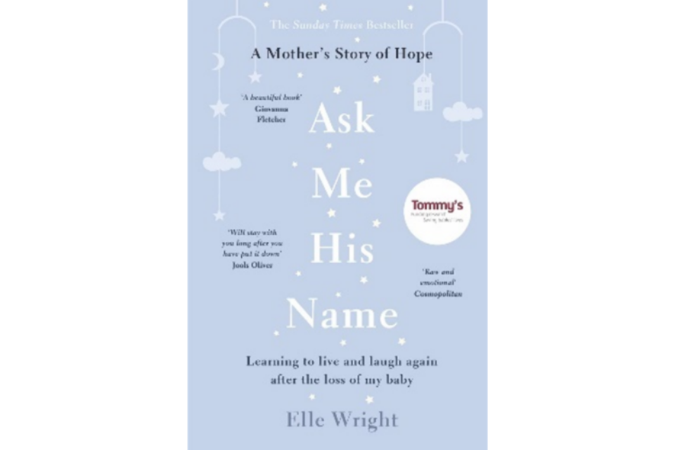 Light blue front cover of 'Ask me his name', with white baby mobiles hanging from the top.