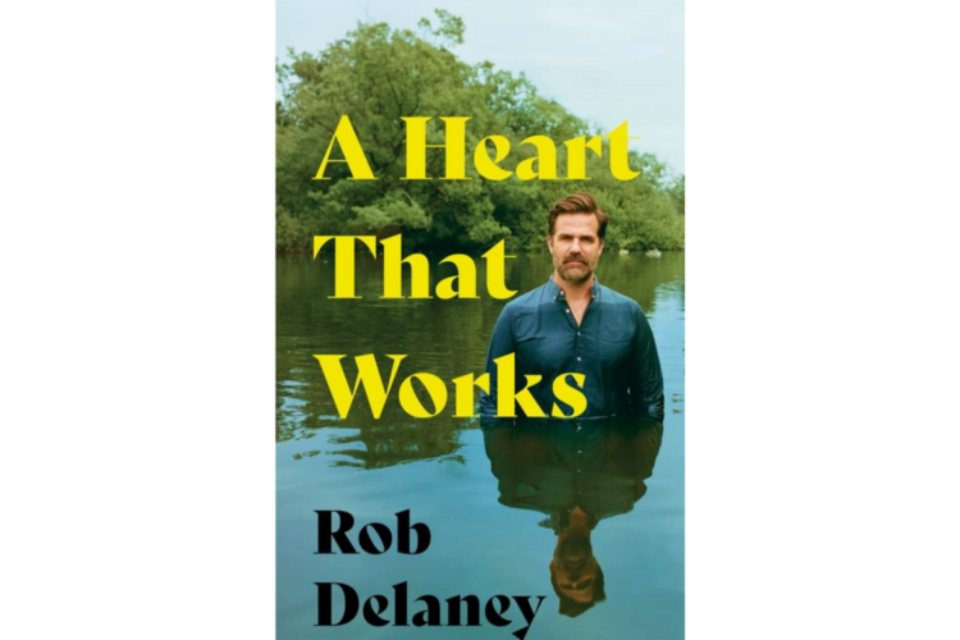 Front cover of 'A Heart That Works'. A man is standing wait deep in a river, looking at the camera.