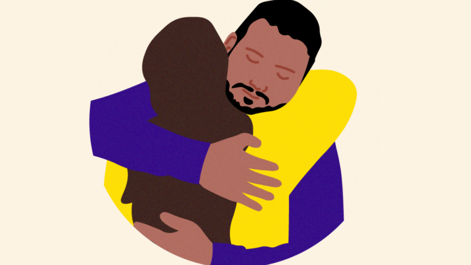 Two people hugging each other supportively.