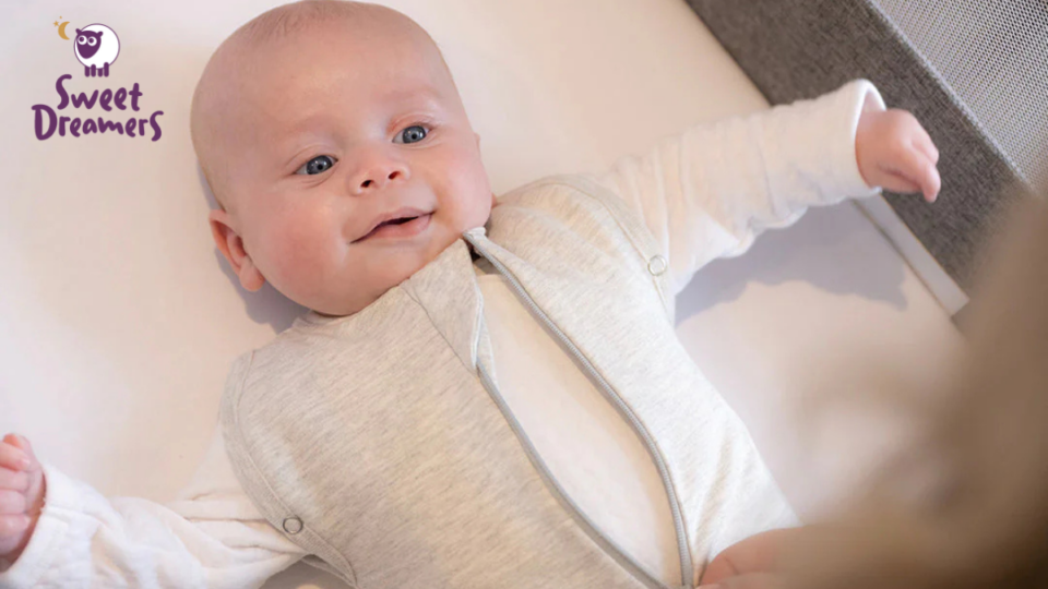 Baby smiling in their cot