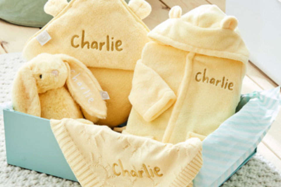 A bundle of yellow baby goods including a teddy and hat.