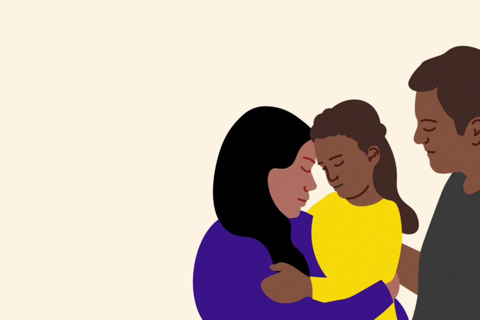 Two parents are holding their daughter in their arms. She is around six years old. They are caring for her.