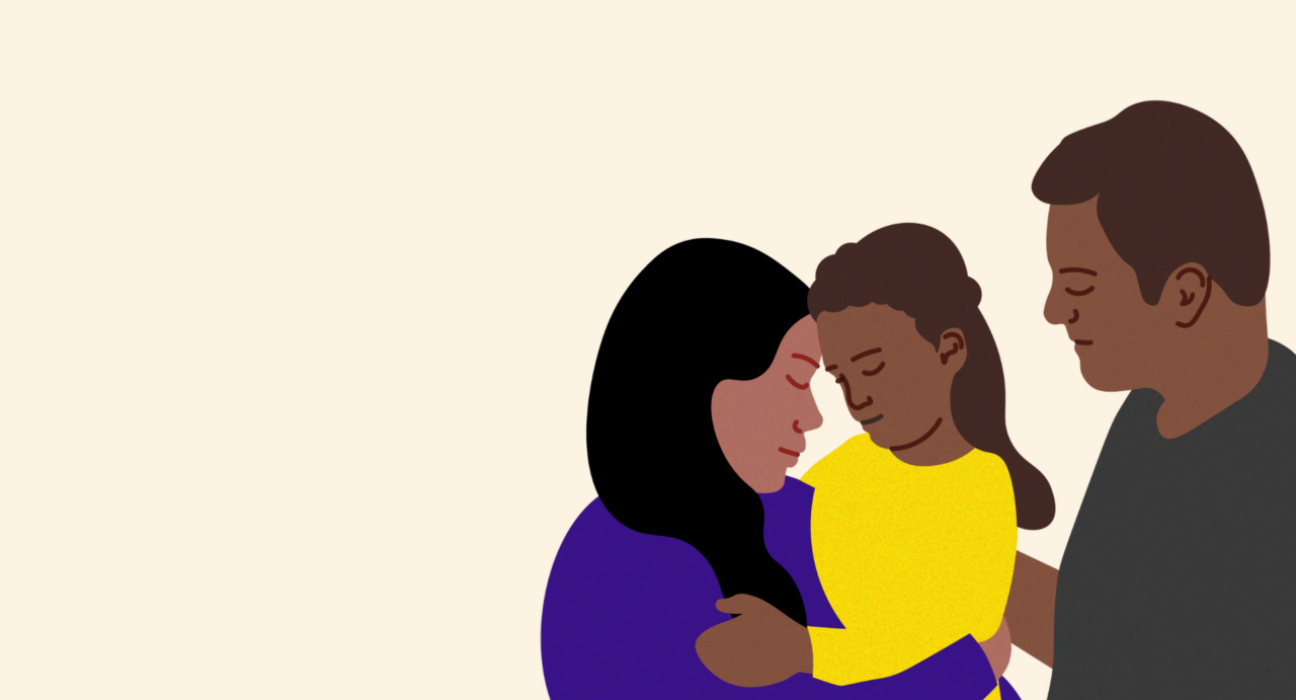 Two parents are holding their daughter in their arms. She is around six years old. They are caring for her.