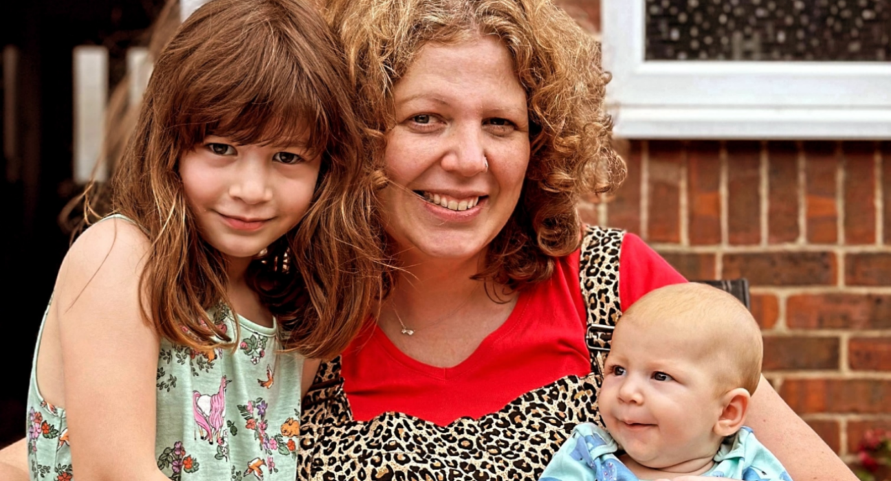 Lucy and her two children smiling at the camera.