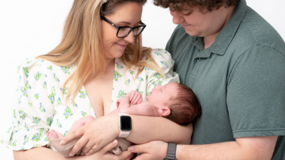 Parent Leanne and Nick holding their baby, Ralph.