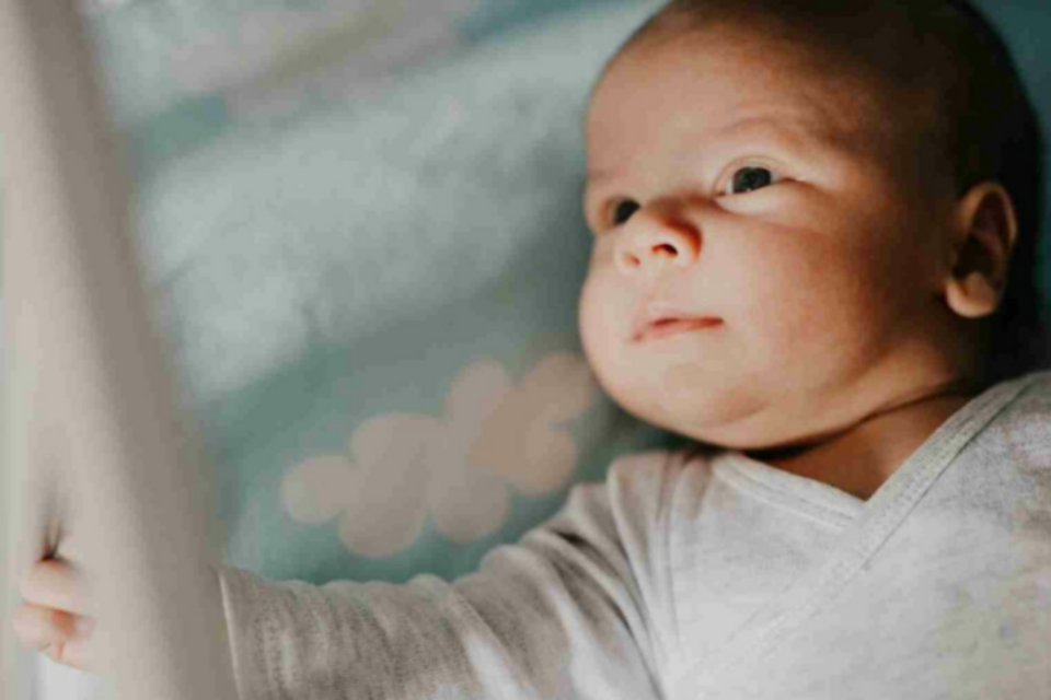 Baby lying down awake.