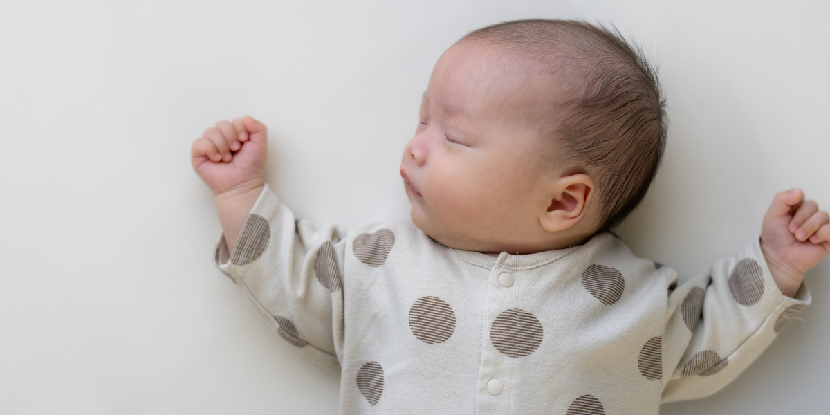 Baby sleeping on their back on a firm, flat surface.