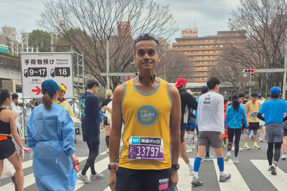 Abs in a Lullaby Trust running vest, at a running event.