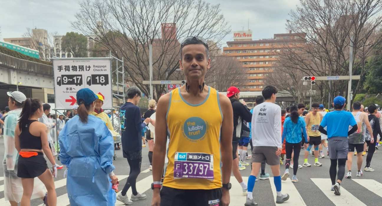Abs in a Lullaby Trust running vest, at a running event.