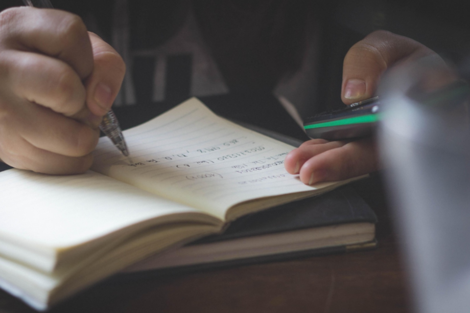 Person writing in a notebook.