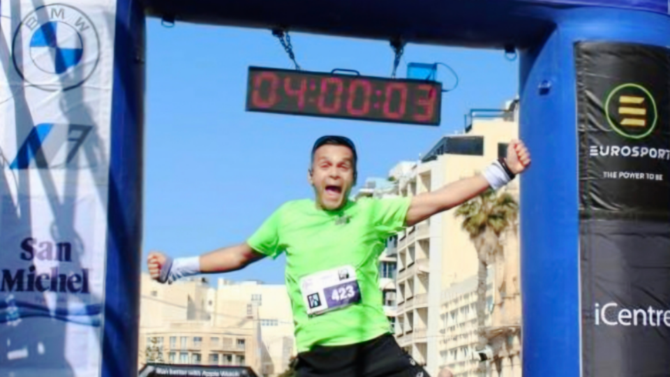Abs at the finish line of a running event, jumping in the air.
