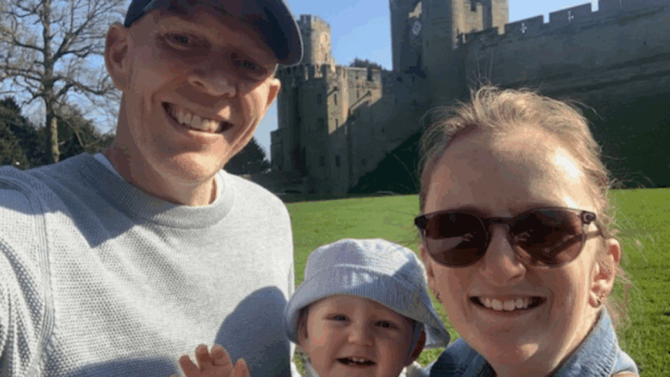Mark taking a selfie, smiling at the camera on a sunny day with his fiancee May and his son Malyn.