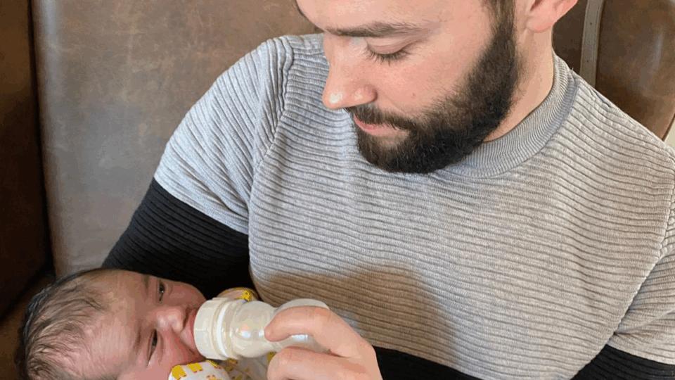 Callum holding Joshua and bottlefeeding him.