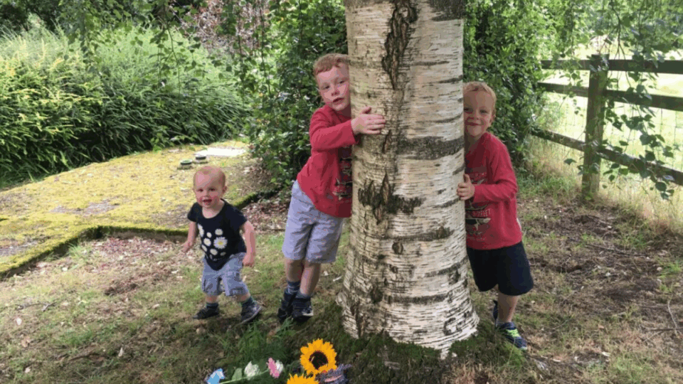 Clare's sons hugging Harry's memorial tree.