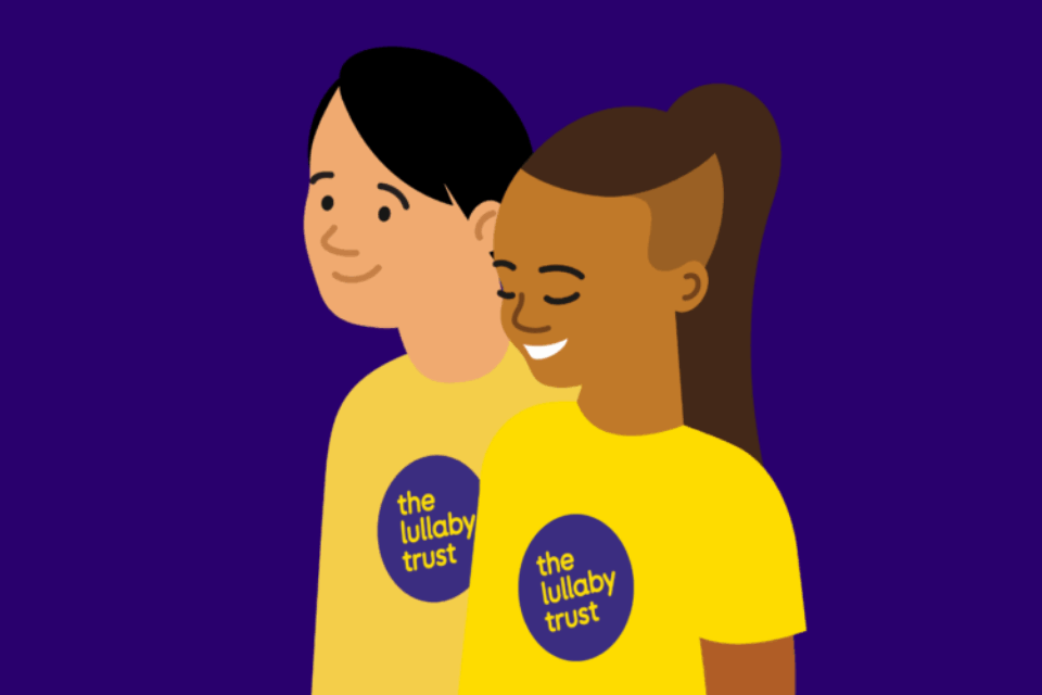 Illustration of two people wearing Lullaby Trust t-shirts. One has medium-dark skin, and the other fair. They are both smiling.