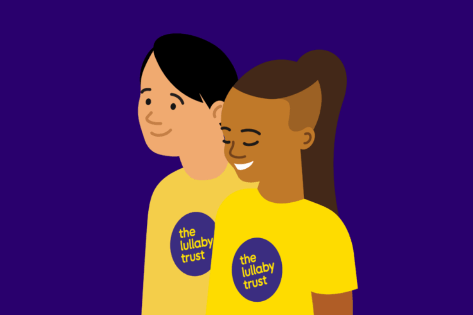 Illustration of two people wearing Lullaby Trust t-shirts. One has medium-dark skin, and the other fair. They are both smiling.