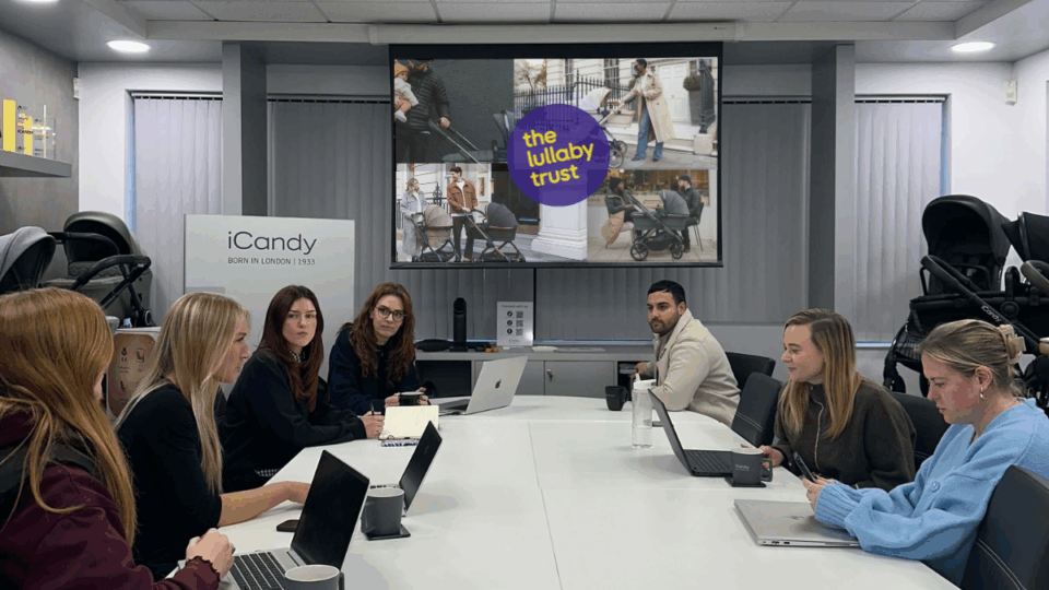 Colleagues sat around a desk listening to a presentation