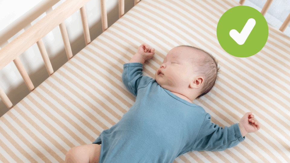 Baby sleeping on their back in a cot. A green tick in the top right corner.