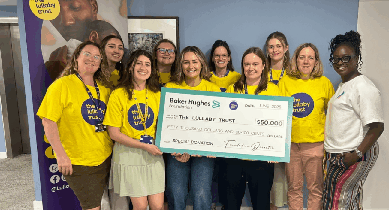 A group of women holding a cheque for $50,000 usd smiling