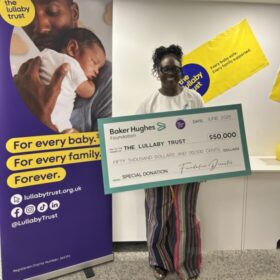 A woman holding a large cheque for $50,000