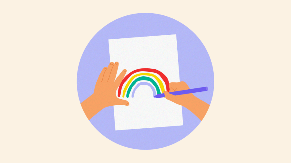 Hands drawing a rainbow on a piece of paper.