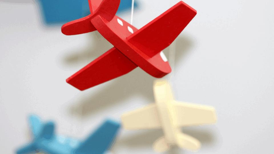 Mobile of airplanes hanging in a baby's bedroom.