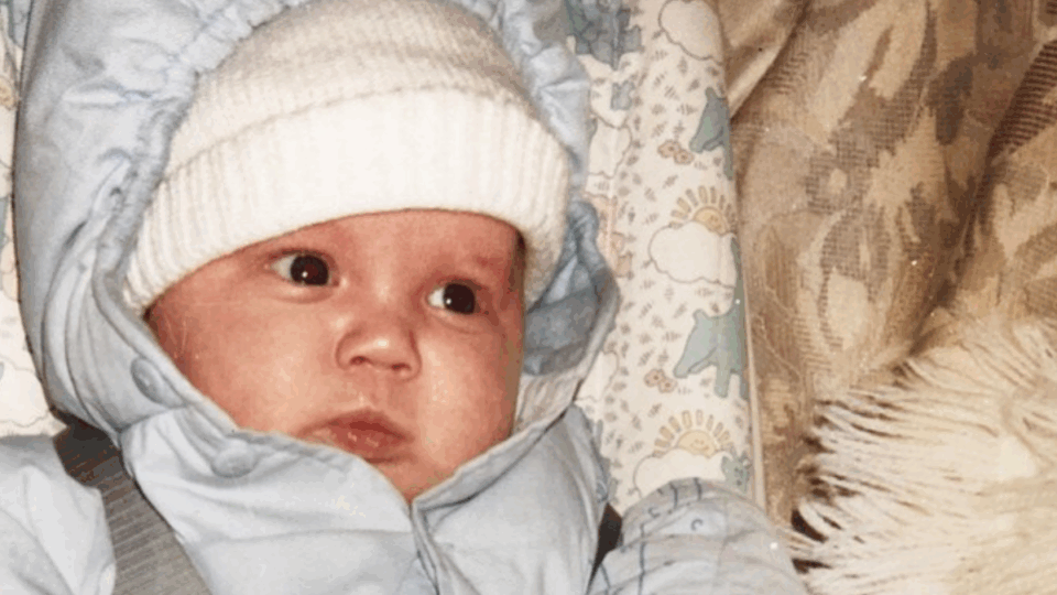Baby Dane wearing a white hat and a jacket.