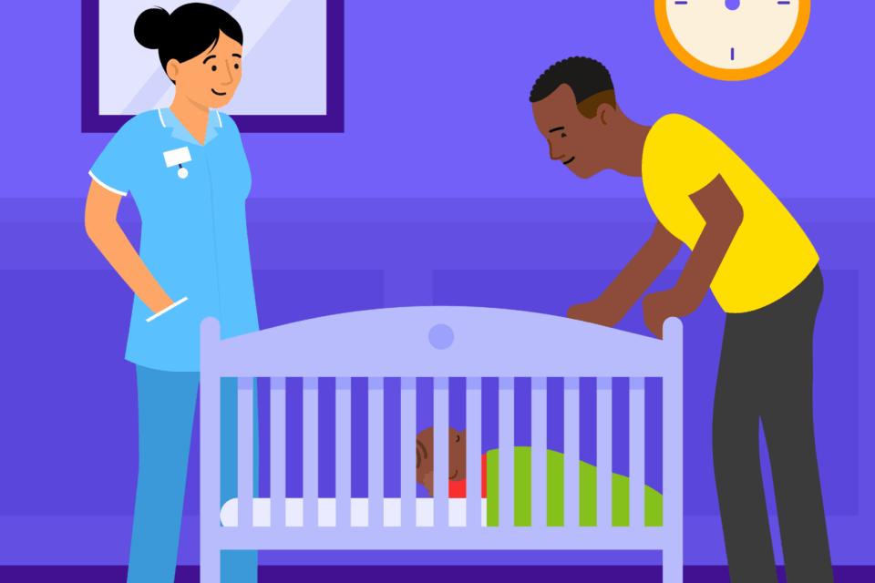 A health professional standing next to a cot, with a father also standing beside the cot. The baby is on their back in the cot.