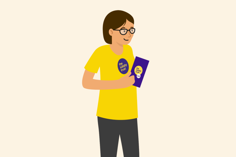Lady wearing a Lullaby Trust t-shirt, holding a clipboard.