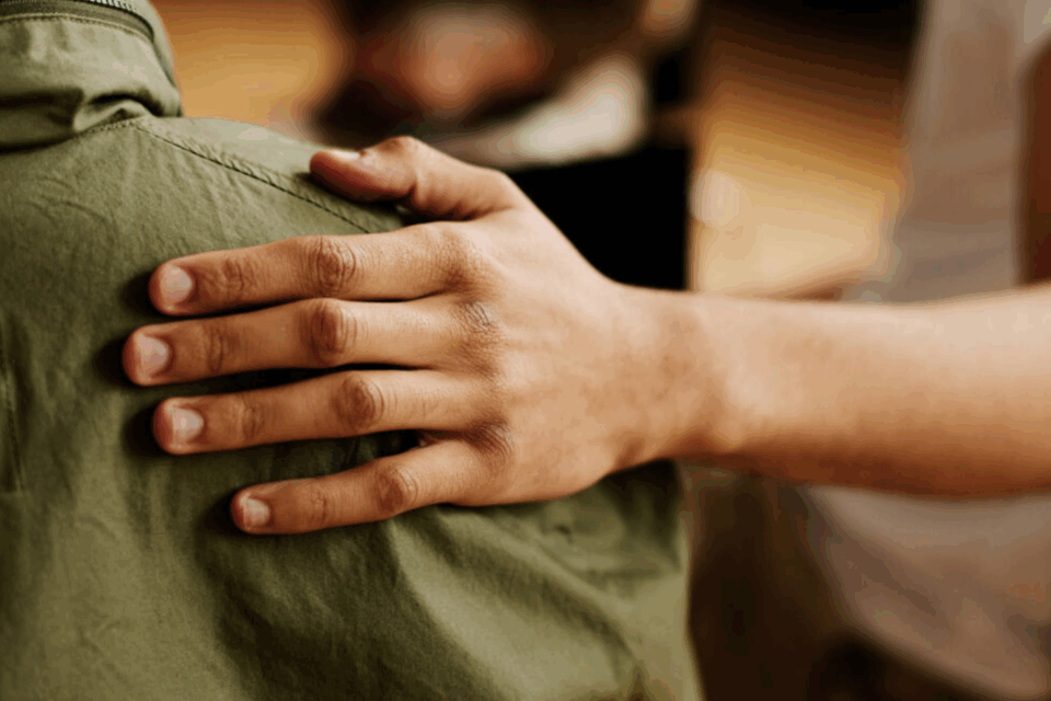Supportive hand on someone's back.