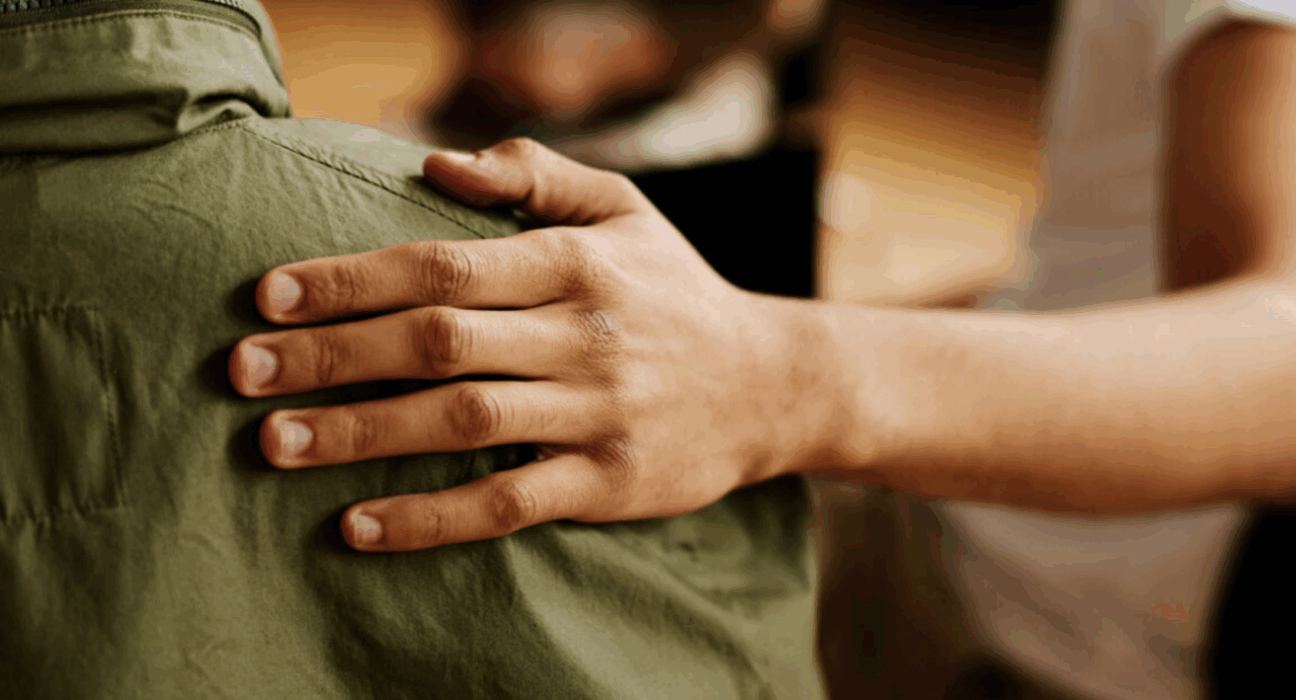 Supportive hand on someone's back.