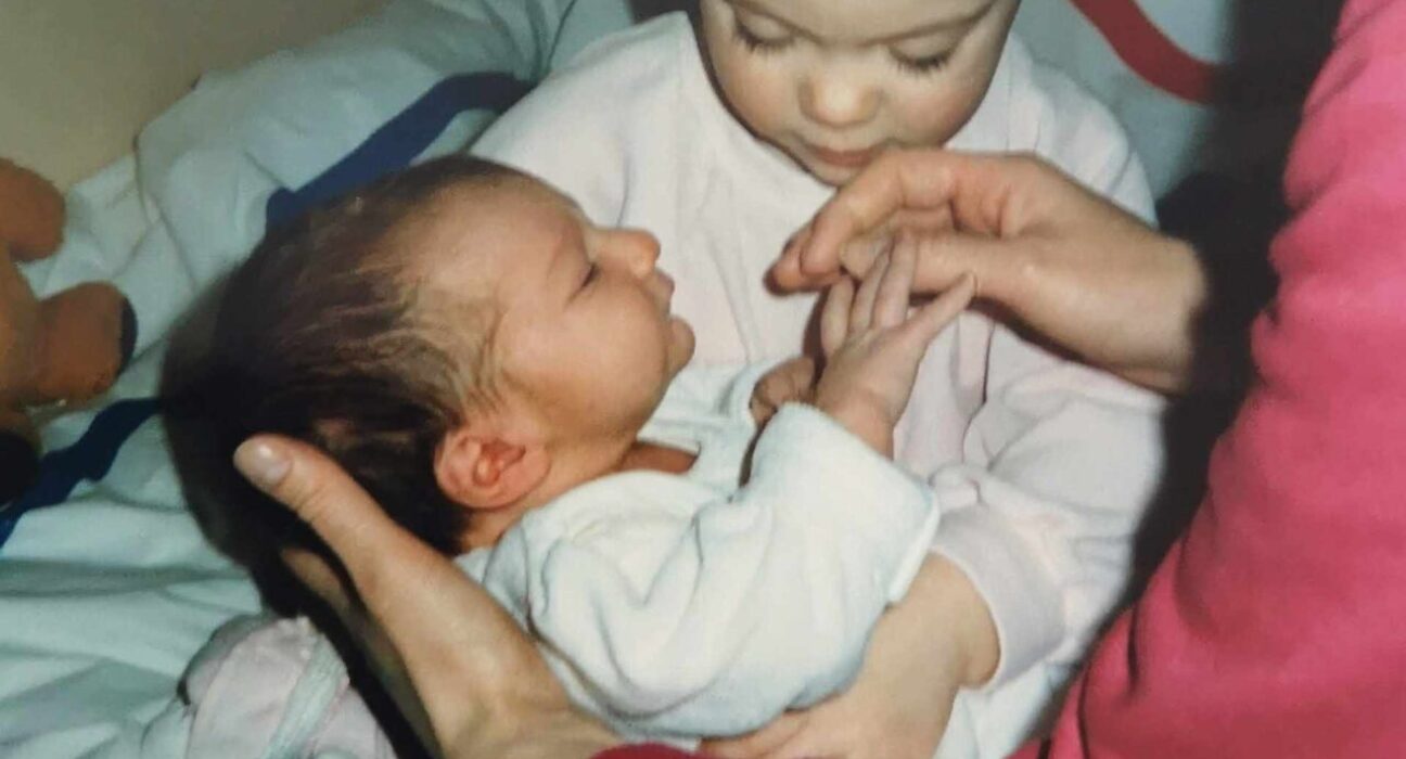 Judi holding baby Adam, with her daughter Vikki beside her.