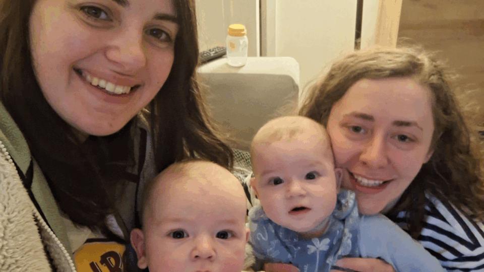 Izzy and Laura holding Alo and Jovie, all smiling at the camera.