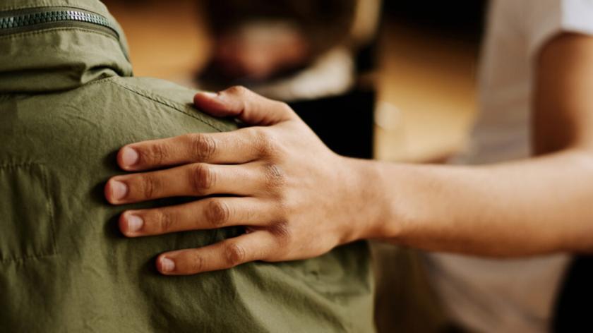 Hand on someone's back in support.